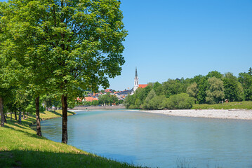 view from the green riverside to old town Bad Tolz with church, summer landscape upper bavaria