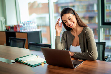 Attractive businesswoman using her laptop at office desk