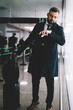 © BullRun - Caucasian businessman 30 years old checking time on modern smartwatch hurry up to airport gate in terminal, formally dressed commuter with luggage suitcase using wrist clock during work travelling