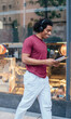 © BullRun - Happy young male student in headphones walking on street