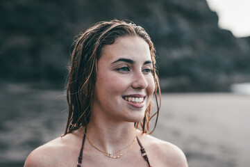 One beautiful young girl looking at the sea smiling and enjoying summertime in pretty beach outdoors. Cute cheerful woman having fun in vacation carefree.