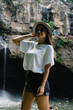© BullRun - Stylish woman enjoying view of waterfall