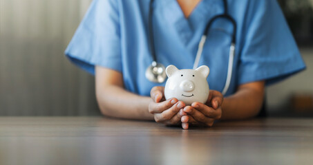 Nurse or doctor with stethoscope holding piggy bank in hand. Concept of medical expenses, finance, saving money, health insurance, medicine, donation and pension. Healthcare service cost.