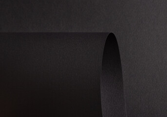 Poster - Charcoal black paper background with curved, matte surfaces and a smooth, grainy texture. Bold dark tones and a dynamic, polished design create a dramatic and refined composition.