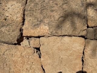 Ancient stone wall with sunlit texture and shadow play