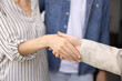© fizkes - Couple of customers shaking hands with real estate insurance agent, mortgage broker, realtor, closing agreement, getting rental, buying house. Close up of handshake
