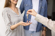 © fizkes - Happy couple of new property owners receiving key from new house from realtor, seller agent. Young husband and wife buying or renting apartment, meeting with real estate broker. Cropped shot