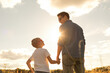 © kieferpix - Father and son holding hands walking in the park, fatherhood, family love, trust, and support concept