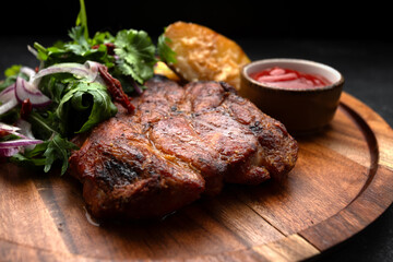 Wall Mural - Grilled meat steak with spicy sauce, baked potato and herbs with onions