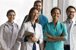 © fizkes - Multiethnic millennial healthcare team, clinic staff members dressed in uniforms posing together, exuding confidence, pride in their profession, medical practice and mission. Teamwork, collaboration