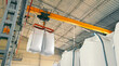 © Iryna - Industrial Crane Lifting Bulk Bags in Warehouse. Close-up of an industrial crane lifting large white bulk bags inside a warehouse