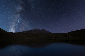 Wall Mural - beautiful night landscape, bright milky way galaxy over the small lake and mountains.