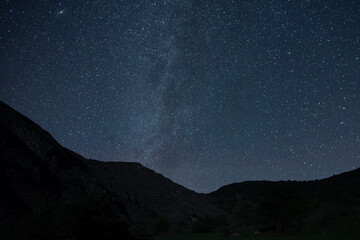 Wall Mural - Beautiful night landscape, Bright Milky Way galaxy over the mountains, starry sky.