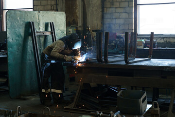 Poster - Skilled welder crafting metal structures in a bustling workshop environment
