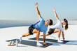 © muse studio - Couple practicing yoga on a rooftop during sunny afternoon