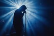 © k - silhouetted singer hooded jacket live concert performance stage blue light smoke music band audience