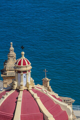 Valletta, Malta. Baroque limestone red cathedral dome overlooks the Mediterranean Sea