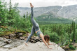 © muse studio - Yoga practice on a rocky outcrop surrounded by lush greenery and mountains in the background