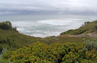 The ocean, dramatic sky and coastal vegetation at Point Lonsdale in Victoria, Australia