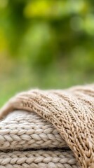 Leinwandbilder - Close-up of folded knitted fabric in soft beige tones against a green backdrop : Generative AI