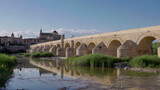 a low angle afternoon view of the ancient roman bridge and the mosque-cathedral of cordoba,spain