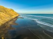 © Zenstratus - Aerial view of a black sand beach, waves, and cliffs. Gentle waves crash on the shore. A few people are visible on the beach. Hamiltons Gap, Awhitu, Auckland, New Zealand