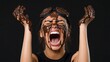 © Sirichai - Chocolate Covered Chaos: A woman covered in chocolate, wearing goggles and screaming with her arms outstretched, against a dark background.