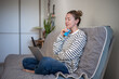© DimaBerlin - Thoughtful woman with laptop and credit card thinking with finances, bills, utilities payments. Doubtful middle aged female sitting on couch online shopping pondering choice, thinks about banking app.