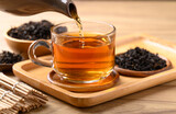 Black tea in cup glass with teapot pouring tea, Healthy herbal drink