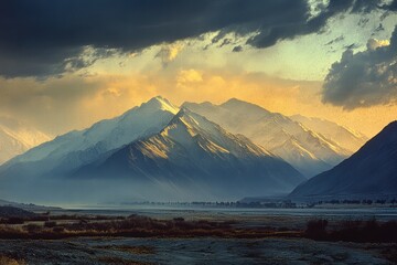 Wall Mural - The silhouette of a mountain range with dark shadows stretching over the land as dusk approaches.