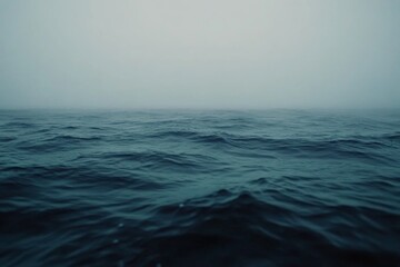 Poster - A massive blue ocean wave rears up under a gray sky, capturing the raw power of nature with its texture and mist, inviting awe and excitement in the viewer