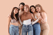© Pixel-Shot - Group of young women hugging on beige background