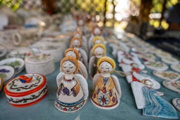 A table full of small figurines, including angels and birds. The table is blue and has a variety of colors and designs