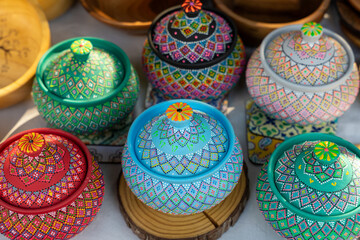 A collection of colorful ceramic bowls with intricate designs. The bowls are arranged on a wooden surface, with some placed closer to the viewer and others further away