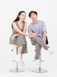 © Bangkok Click Studio - Portrait of lovely young asian happy attractive cheerful couple love, Joyful sweethearts enjoy good time romantic date, sitting on stools posing to camera smiling against together on white background.