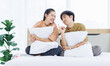 © Bangkok Click Studio - Portrait of young lovely sweet attractive asian happy couple love posing to camera smiling hugging pillow sitting on white bed in bedroom at home good time romantic together Valentine's day concept.