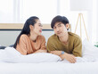 © Bangkok Click Studio - Portrait of young asian lovely sweet attractive cheerful happy couple love smile playing and relax on white bed in bedroom at home good time romantic together Valentine's Day and relationship concept.