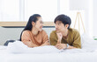 © Bangkok Click Studio - Portrait of young asian lovely sweet attractive cheerful happy couple love smile playing and relax on white bed in bedroom at home good time romantic together Valentine's Day and relationship concept.