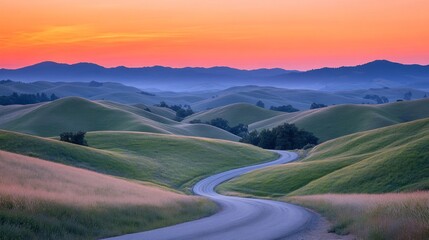 Poster - A winding road elegantly curves through rolling green hills as the sun sets, painting the sky with hues of orange and purple, inviting exploration and tranquility