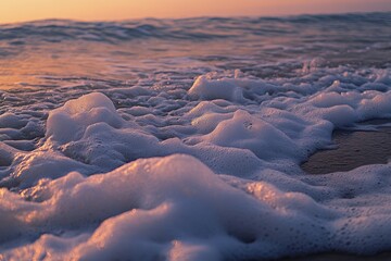 Poster - Foamy water on a beach at sunset with vibrant colors and warm light