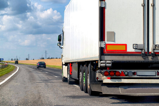 A beautiful truck transports cargo along the highway in the summer. Concept of a cargo transport company. Work and vacancies as a freight forwarder driver. Copy space for text
