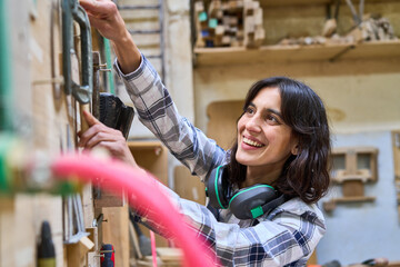 Wall Mural - Young woman working in a lumberyard with enthusiasm and skill