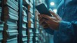 © Planetz - Man Holding Smartphone Surrounded by Stacks of Documents in Indoor Archive Setting While Engaged in Important Tasks and Communication