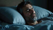 © Miklos - Man peacefully sleeping in a dimly lit bedroom with soft blue bedding at night