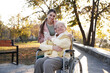 © New Africa - Caregiver with elderly woman in wheelchair at park