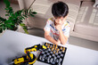 © sorapop - Asian little boy thinking and wait robot arm playing chess, STEM education E-learning, Funny children learning successful getting a lesson control robot arm game, Technology science education concept