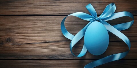 Easter craft display featuring a blue satin ribbon wrapped around a blue egg on a rustic wooden background with soft natural lighting