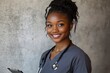 © AnCreaSpace - Smiling African American nurse wearing scrubs and stethoscope holding a clipboard looking friendly