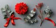 © Lala - Vibrant red flower and eucalyptus arrangement with red ribbon on gray background in flat lay style showcasing ample copy space for text.