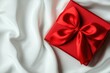 © Arfa_Media - Red gift box with satin ribbon bow on white silk fabric